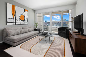 a living room with a couch and a tv and a balcony