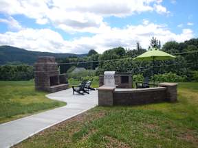 A green umbrella is on a table in a park.