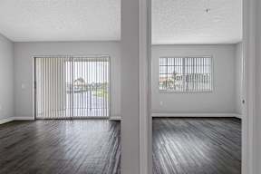 an empty living room with wood floors and a sliding glass door