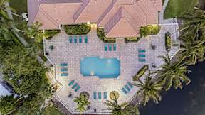 a pool is circled by chairs and palm trees