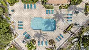 an overhead view of a swimming pool with umbrellas and chairs