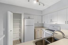 a white kitchen with white appliances and white cabinets
