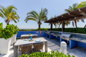 a patio with tables and chairs and a grill