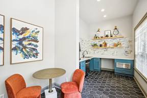 A kitchen with a table and chairs in front of it.