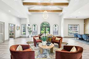 A large, modern living room with a variety of seating options and a large window.