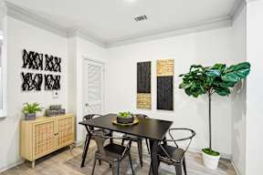 A dining room with a table and chairs.