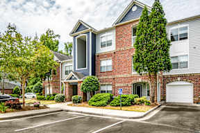 A blue and white building with a parking lot in front.