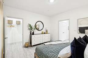 A bedroom with a bed, dresser, and mirror.