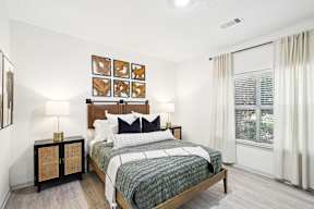 A bedroom with a bed, nightstand, and a wall art.
