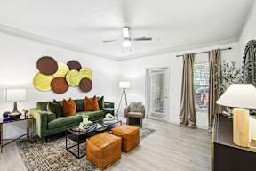 A living room with a green couch and a wall art of circles.