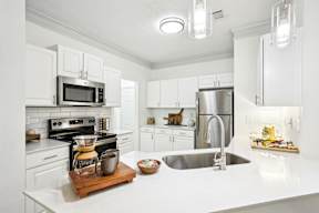 A kitchen with white cabinets and a white counter top.