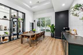 A modern kitchen with a wooden table and chairs.
