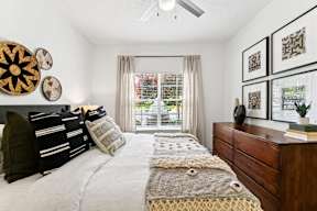 A bedroom with a bed, pillows, and decorative items on the wall.