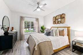 A bedroom with a large bed and a ceiling fan.