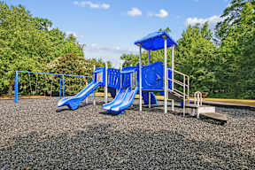 A playground with a blue slide and a blue canopy.