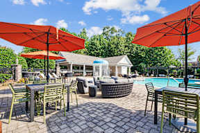 A patio with tables and chairs and umbrellas.
