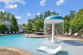 A large blue and white water fountain in the middle of a pool.