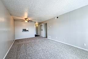 A room with a ceiling fan and a door.