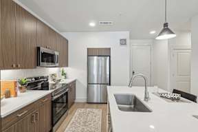 a modern kitchen with stainless steel appliances and a white counter top