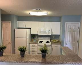 A kitchen with a granite countertop and white appliances.