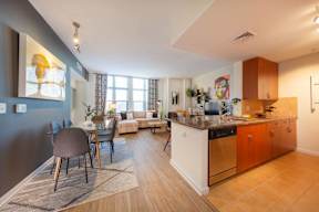A kitchen with a dining table and chairs.