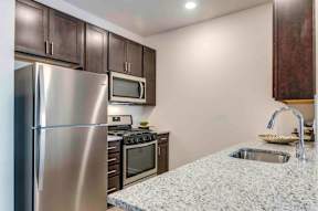 A kitchen with a granite countertop and stainless steel appliances.