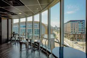 A room with a table and chairs with a view of the city.