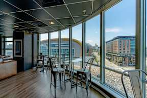 A room with a table and chairs with a view of the outside.