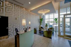 A reception area with a green desk and a black door.