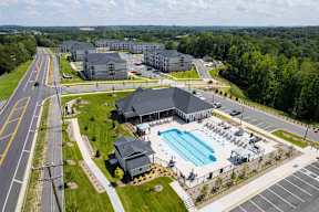 A large building with a pool in front of it.