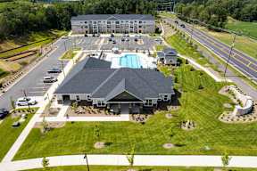 A large building with a pool in the middle of a grassy area.