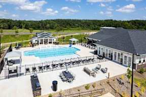 A large outdoor pool area with a building in the background.
