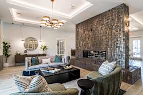 A modern living room with a fireplace and a large mirror on the wall.