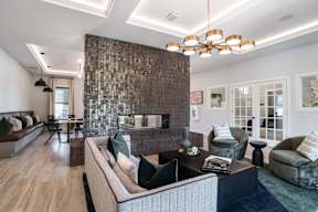 A modern living room with a stone wall and a large couch.