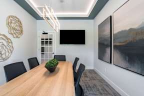 A dining room with a wooden table and chairs.
