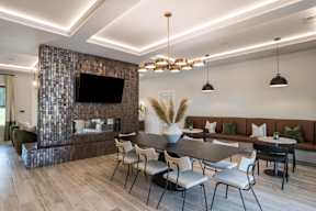 A modern dining room with a dark wood table and chairs.