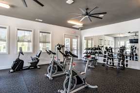 A spacious gym with a variety of exercise equipment including treadmills, stationary bikes, and weight machines.