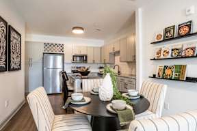 A modern kitchen with a dining table set for two.