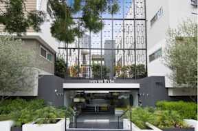 A modern building with a glass facade and a sign that reads "ninety five five".