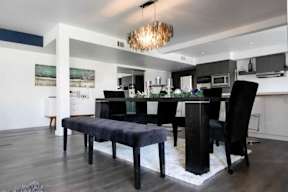 A modern dining room with a black table and chairs.