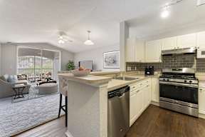 A modern kitchen with a dining area and a living room.