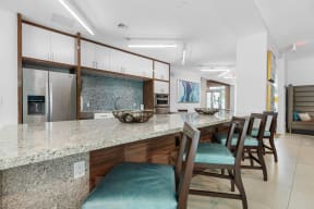 a kitchen with a long counter and a bar with chairs