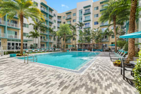 a swimming pool at an apartment complex with palm trees