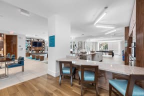 a lobby with a bar and chairs and a kitchen