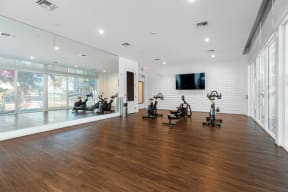 the home gym has treadmills and a television on the wall