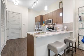 a kitchen with a bar and stools in a 555 waverly residences apartment