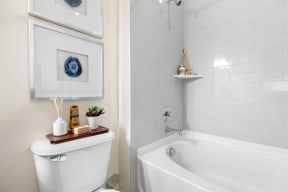 a white bathroom with a tub and a toilet and a sink