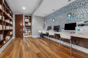 a home office with a blue and white wallpaper and a desk with two computer monitors