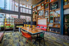 a dining room with a table and chairs in front of a wall filled with shelves