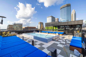 a pool on the roof of a building with a city in the background